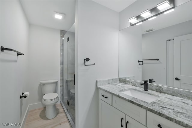 bathroom with vanity, hardwood / wood-style floors, an enclosed shower, and toilet