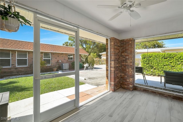 doorway to outside with wood-type flooring and ceiling fan