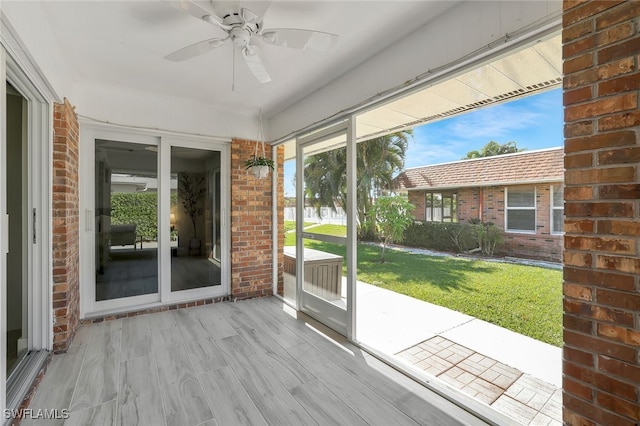 unfurnished sunroom with ceiling fan