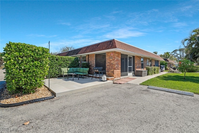 view of front facade featuring a patio, an outdoor hangout area, and a front lawn