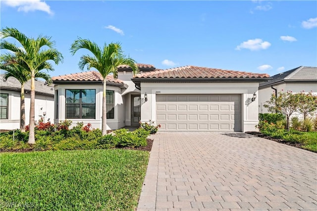 mediterranean / spanish-style home with a garage and a front lawn