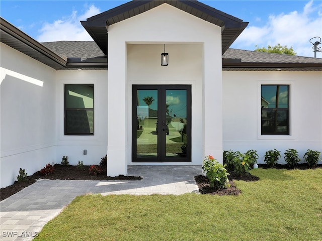 property entrance with a lawn and french doors