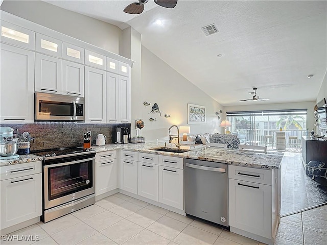 kitchen with sink, ceiling fan, appliances with stainless steel finishes, white cabinetry, and kitchen peninsula