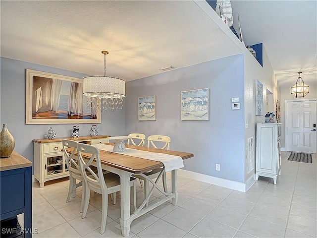 dining space with an inviting chandelier and light tile patterned floors