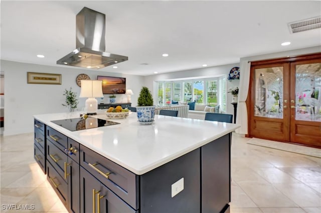 kitchen featuring gray cabinetry, black electric stovetop, french doors, island exhaust hood, and a center island