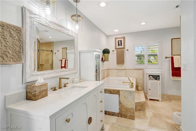 bathroom with vanity and shower with separate bathtub