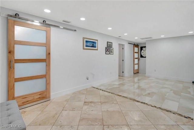 basement with light tile patterned floors and a barn door