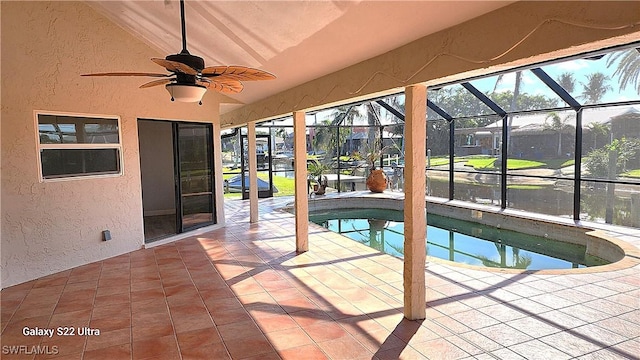 view of swimming pool featuring ceiling fan, a lanai, and a patio area