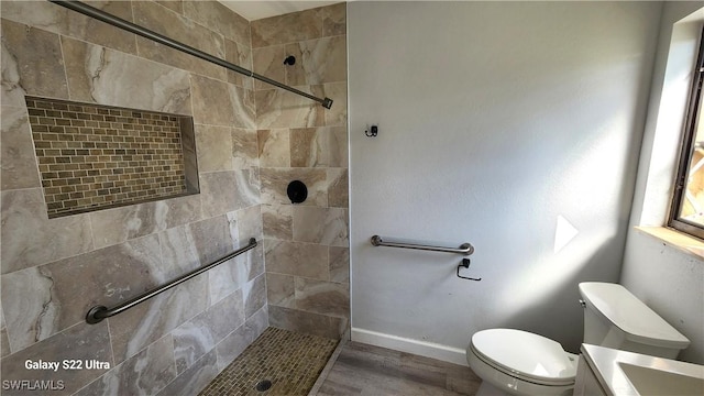 bathroom with vanity, hardwood / wood-style floors, toilet, and tiled shower