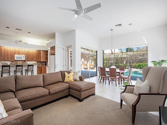 tiled living room with a wealth of natural light and ceiling fan