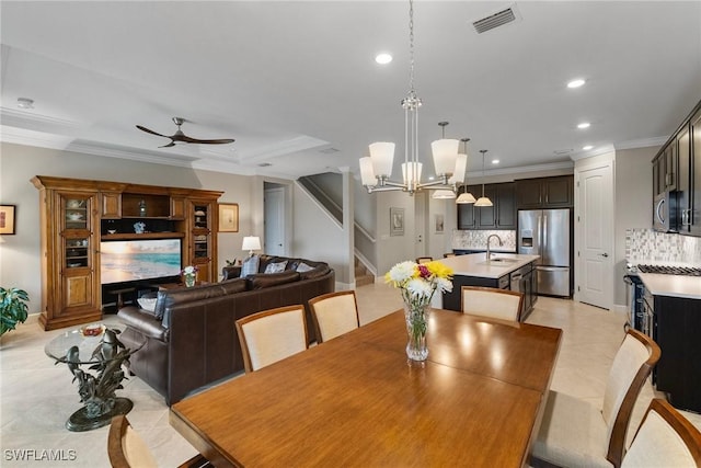 dining room with ceiling fan with notable chandelier, ornamental molding, sink, and light tile patterned floors