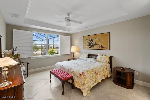 bedroom with ceiling fan, light tile patterned floors, and a raised ceiling