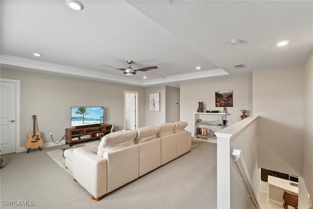 living room with light carpet, ceiling fan, crown molding, and a raised ceiling