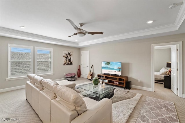 carpeted living room with ornamental molding, ceiling fan, and a raised ceiling