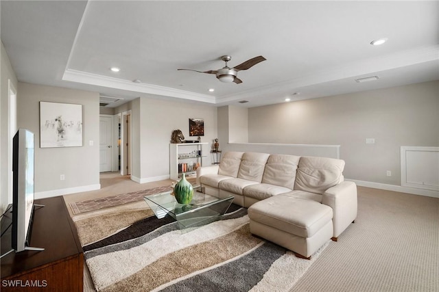 carpeted living room featuring ornamental molding, ceiling fan, and a raised ceiling