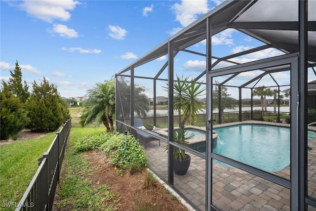 view of swimming pool with a yard, a water view, pool water feature, a patio, and glass enclosure