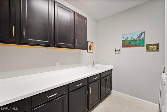 laundry area featuring sink, washer and clothes dryer, and cabinets