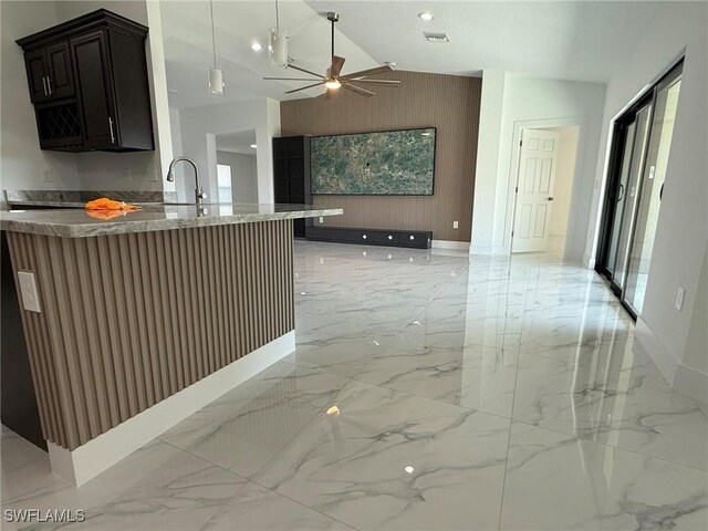 kitchen with sink, stone countertops, wooden walls, kitchen peninsula, and ceiling fan