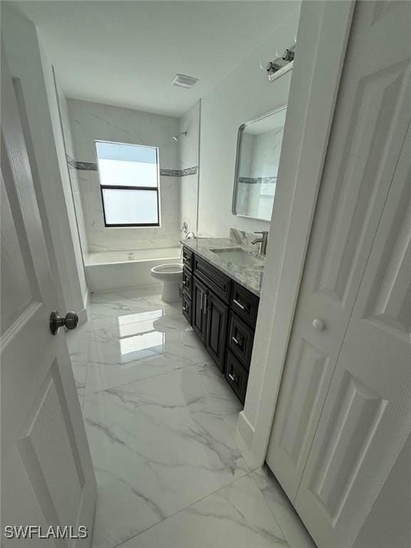 full bathroom featuring tiled shower / bath, vanity, and toilet