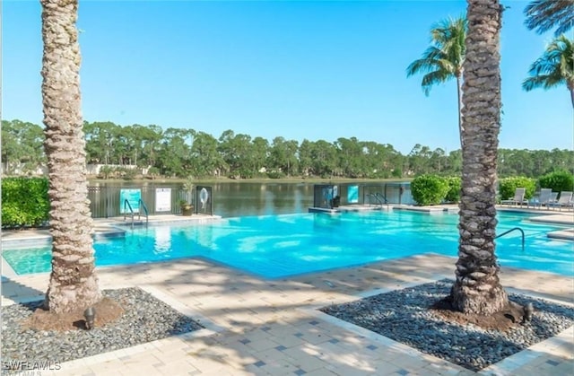 view of pool with a patio and a water view