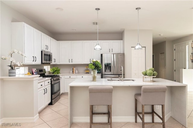 kitchen featuring white cabinetry, decorative light fixtures, stainless steel appliances, and a breakfast bar