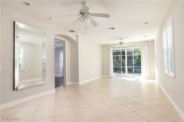 spare room with ceiling fan and light tile patterned floors