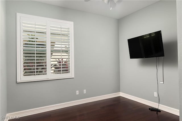 spare room with dark wood-type flooring and ceiling fan