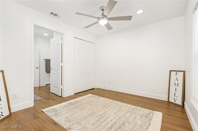 unfurnished bedroom with hardwood / wood-style floors, a closet, and ceiling fan