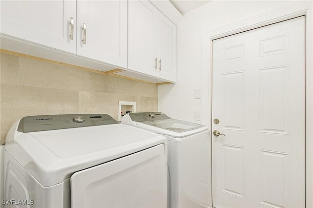 washroom featuring cabinets and separate washer and dryer