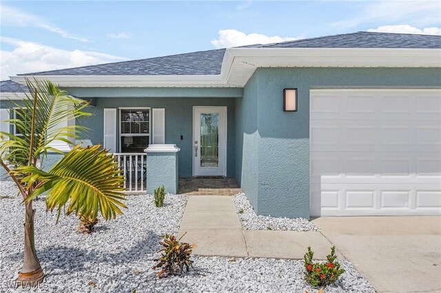 entrance to property featuring a garage and covered porch