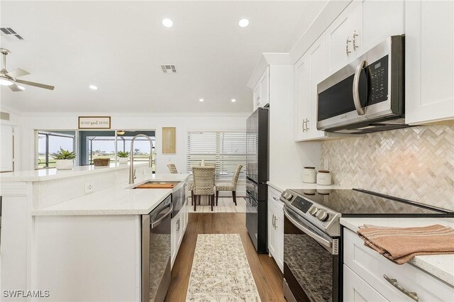 kitchen with sink, ornamental molding, white cabinets, and appliances with stainless steel finishes