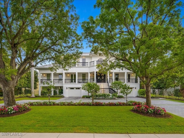 view of front of home with a garage, a front lawn, and a porch