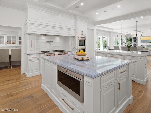 kitchen with a kitchen island, white cabinets, and appliances with stainless steel finishes