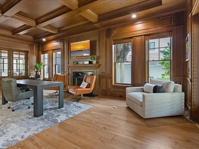 sitting room with coffered ceiling, a fireplace, wooden walls, and beam ceiling