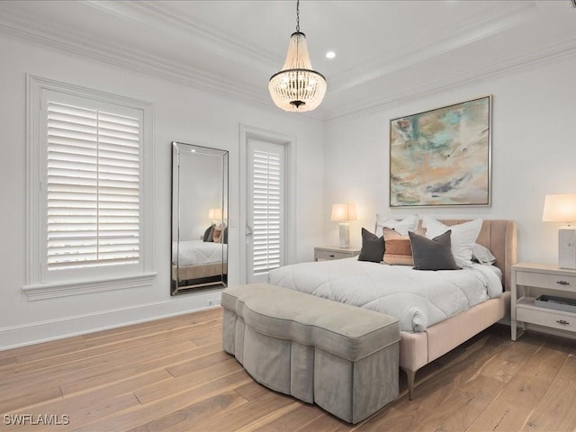 bedroom with ornamental molding, light hardwood / wood-style floors, and a notable chandelier