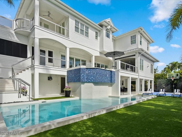 back of property featuring a balcony and a yard