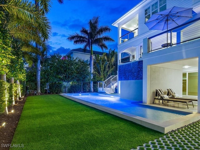 yard at dusk with a balcony and a patio area