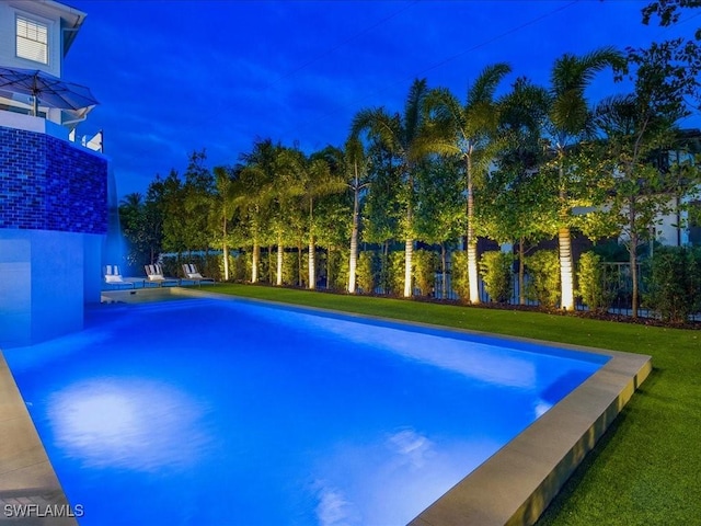 view of swimming pool featuring a yard