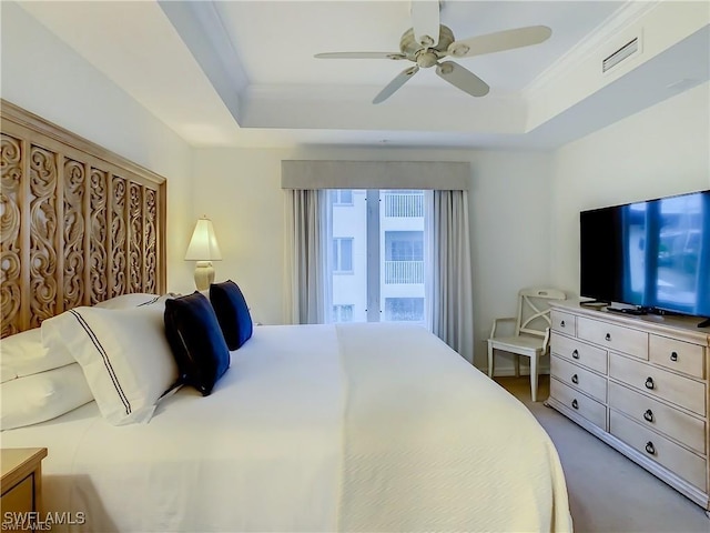 carpeted bedroom featuring crown molding, ceiling fan, and a tray ceiling