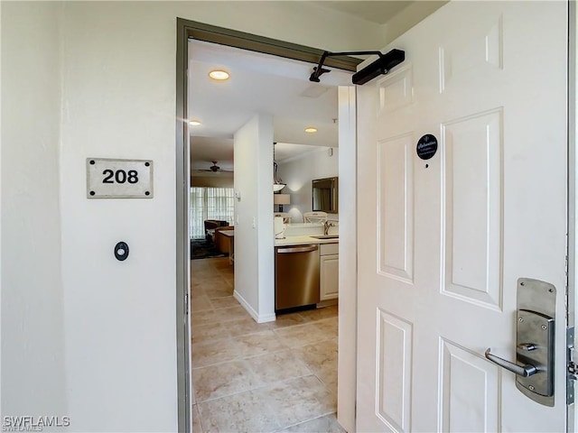 hallway featuring sink and light tile patterned flooring