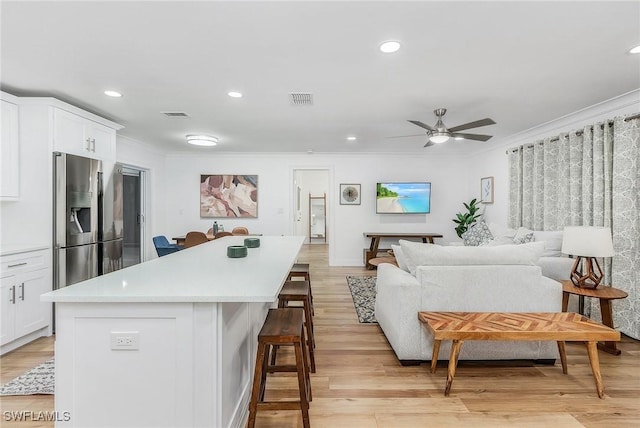 living room with crown molding, ceiling fan, and light hardwood / wood-style floors