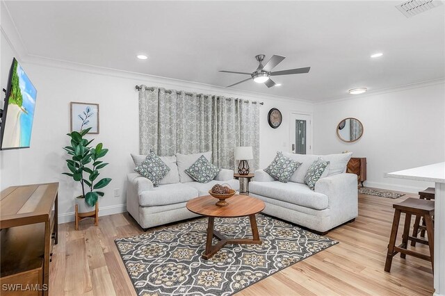 living room with ornamental molding, hardwood / wood-style floors, and ceiling fan