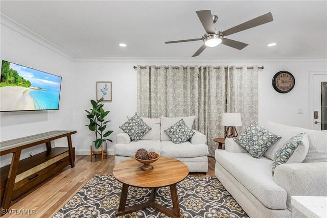 living room featuring crown molding, light hardwood / wood-style floors, and ceiling fan