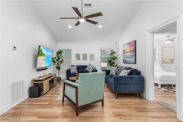 living room with crown molding, ceiling fan, and light hardwood / wood-style floors