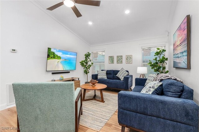 living room with crown molding, plenty of natural light, vaulted ceiling, and hardwood / wood-style floors