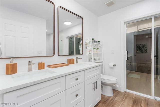 bathroom with vanity, wood-type flooring, and toilet