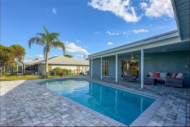 view of swimming pool with ceiling fan, outdoor lounge area, and a patio area