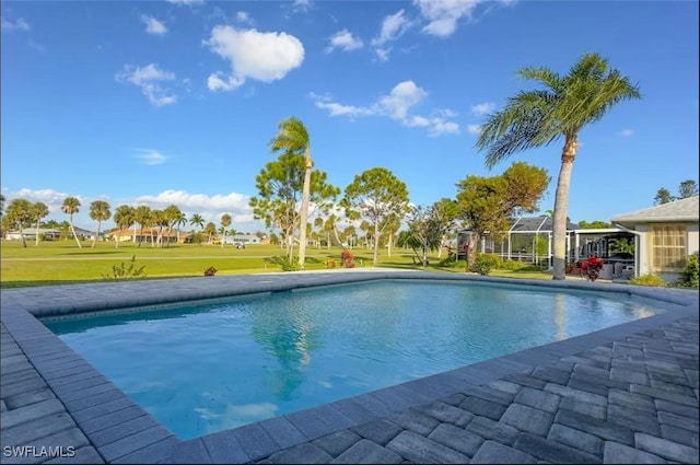 view of pool featuring glass enclosure and a lawn