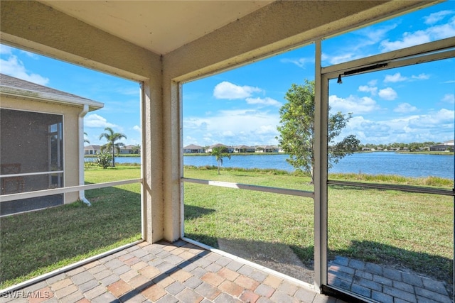 unfurnished sunroom featuring a water view