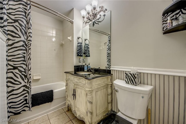 full bathroom with tiled shower / bath, a chandelier, tile patterned flooring, vanity, and toilet